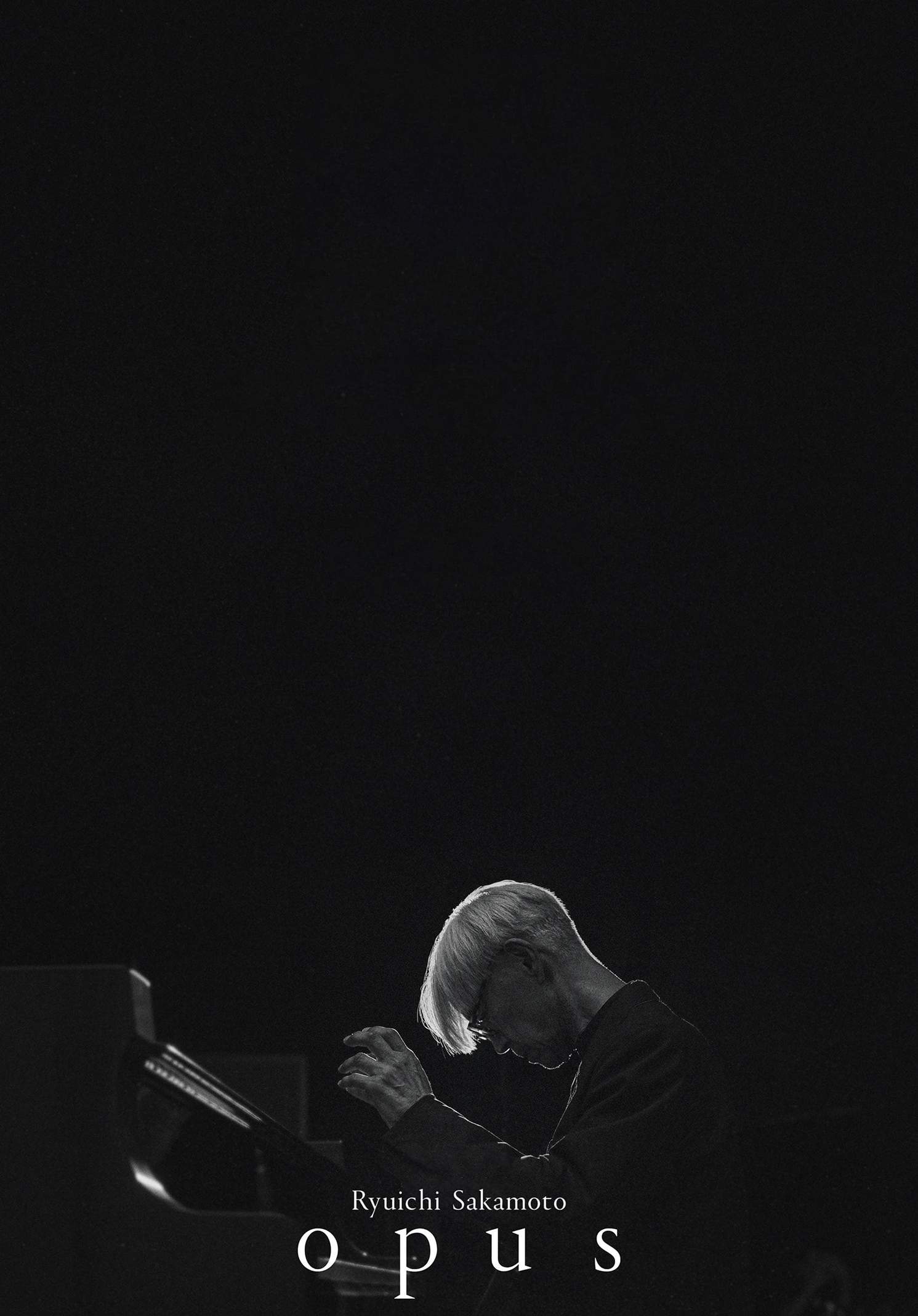 Black & white poster of Ryuichi Sakamoto playing piano, for his final film and performance, 'Opus'