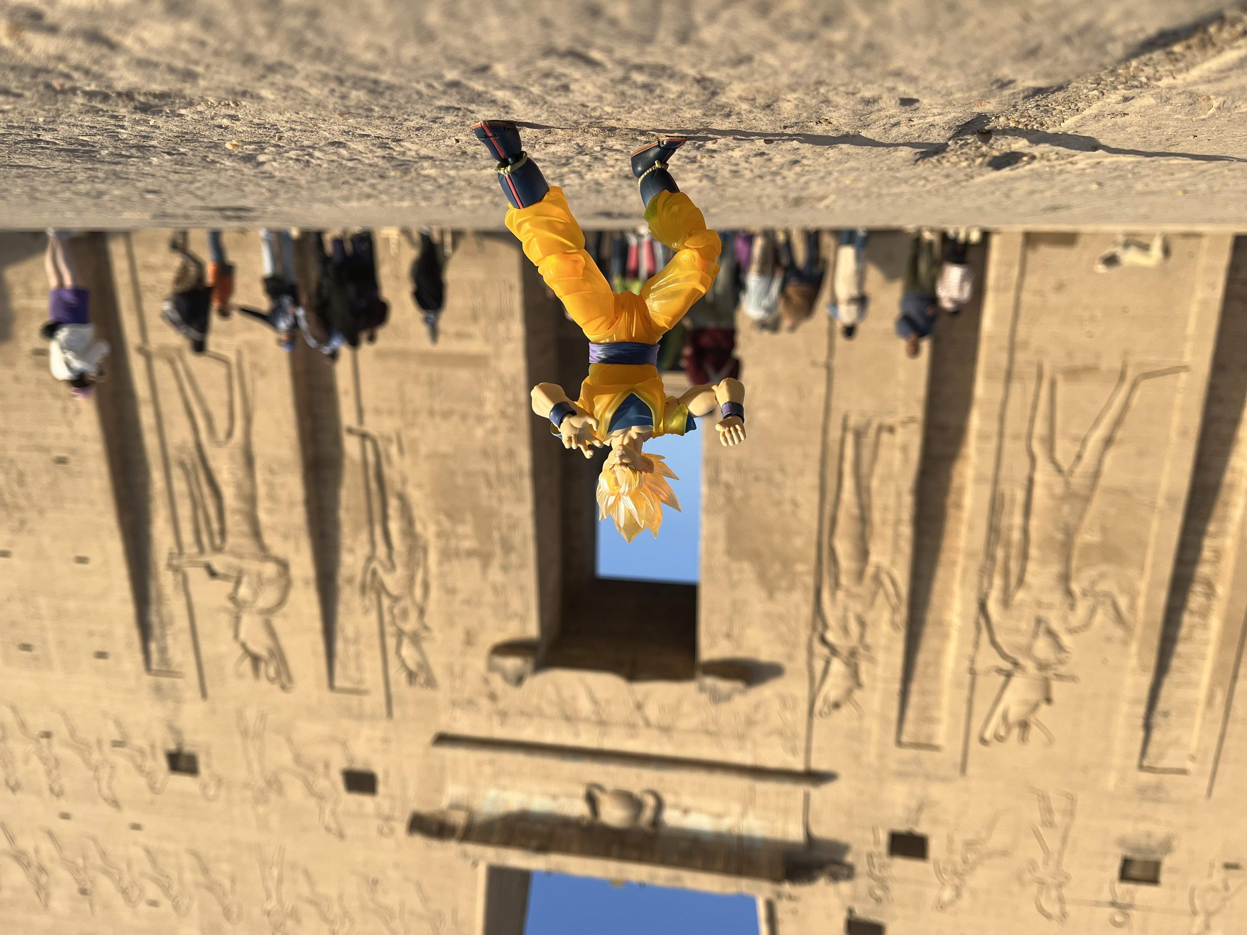 Super Saiyan Goku figure in a combat pose in front of Edfu Temple, Egypt